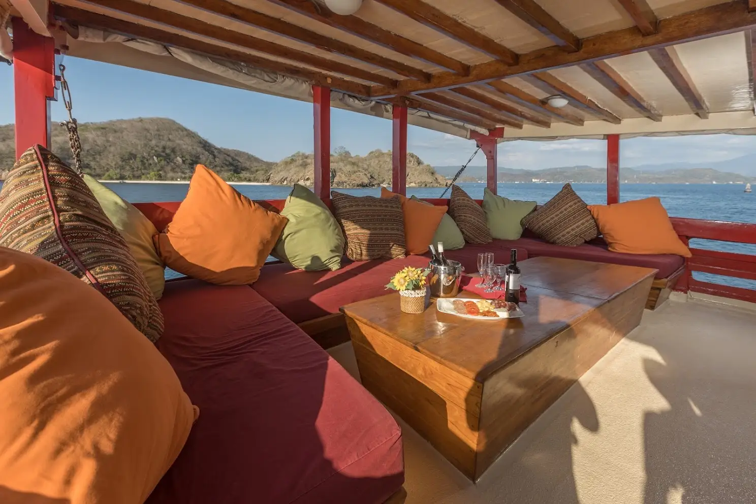 Shaded open-air lounge with cushioned banquette seating on Seven Seas Liveaboard | Komodo Luxury